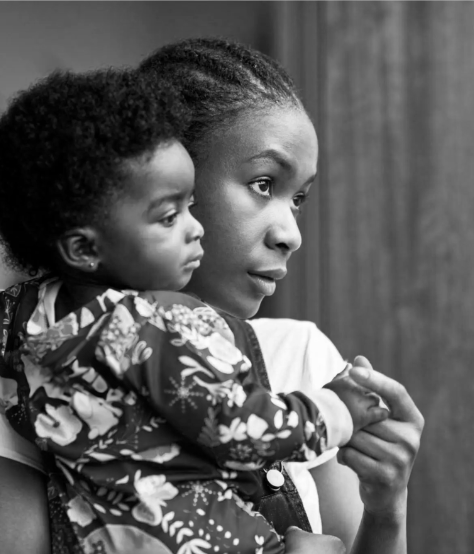 Four black and white photos appear in equal squares, from left to right: a man entering an MRI machine, an infant girl held and holding hands with her mother, a boy leaning on his father’s back, and a young girl lying on an adult’s chest.