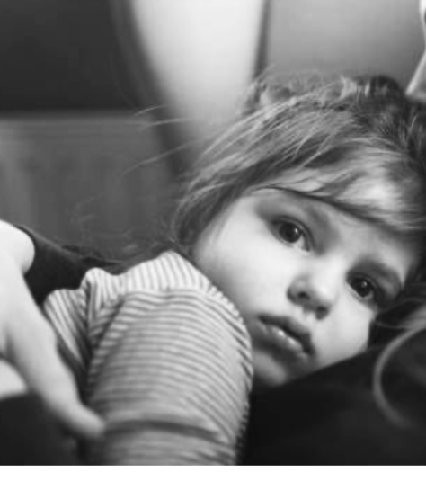 Four black and white photos appear in equal squares, from left to right: a man entering an MRI machine, an infant girl held and holding hands with her mother, a boy leaning on his father’s back, and a young girl lying on an adult’s chest.