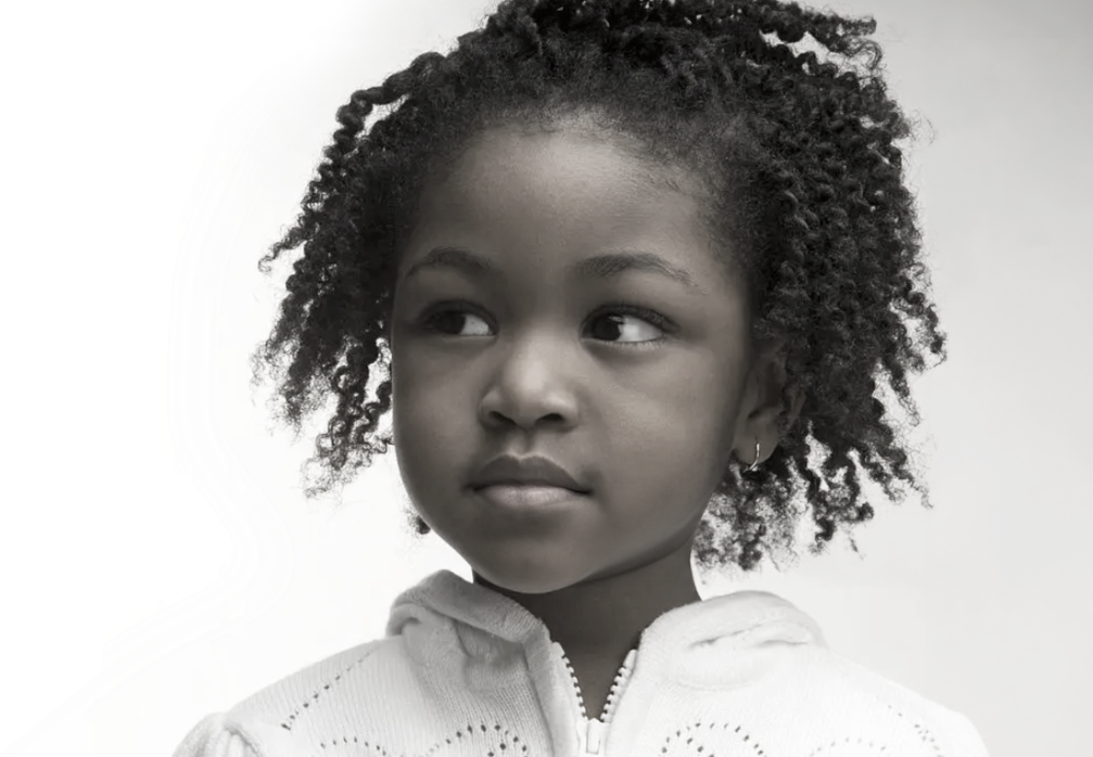 A black and white photo of a young girl.
