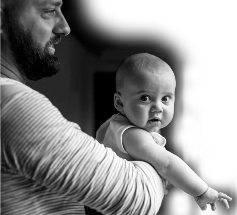 A black and white photo of a man holding an infant.
